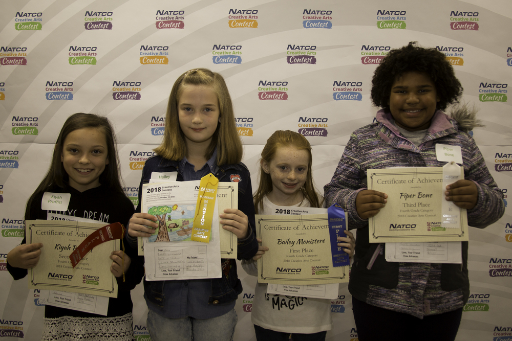 Group of 4 children holding certificates from natco