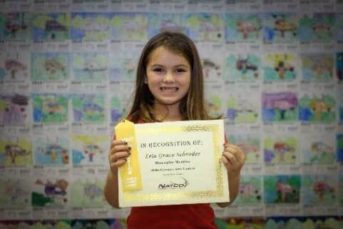 Child holding award certificate