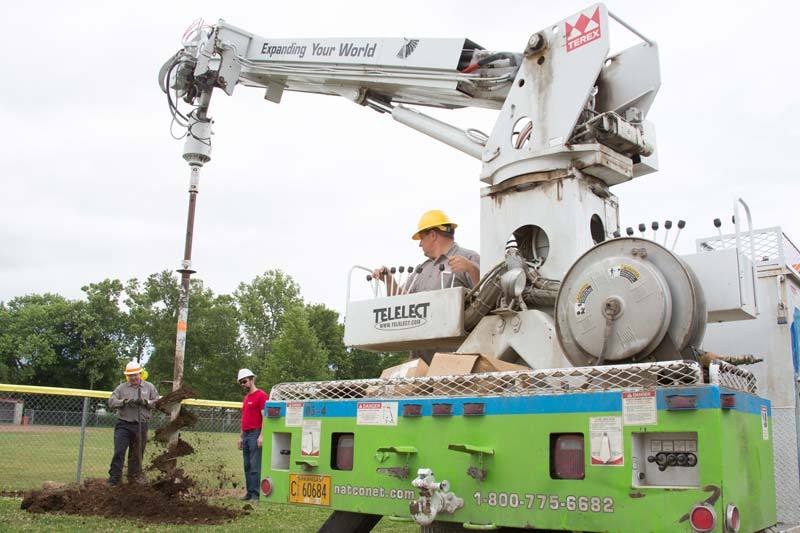 NATCO Crew drilling holes for Flippin ball field